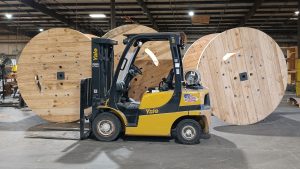 Three specialty 96" reels next to a forklift